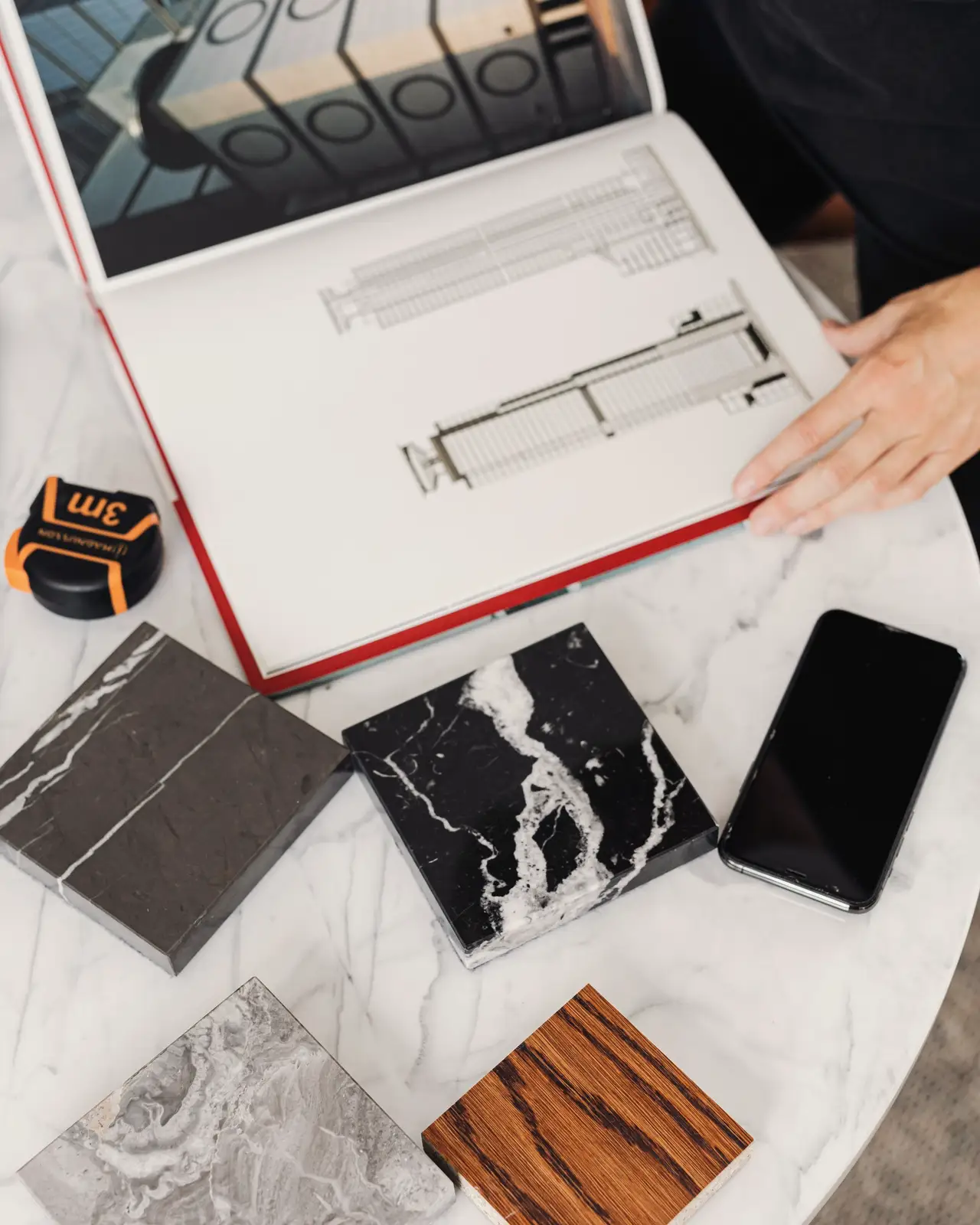 Finish samples, stone and wood swatches and a sketchbook on the studio table